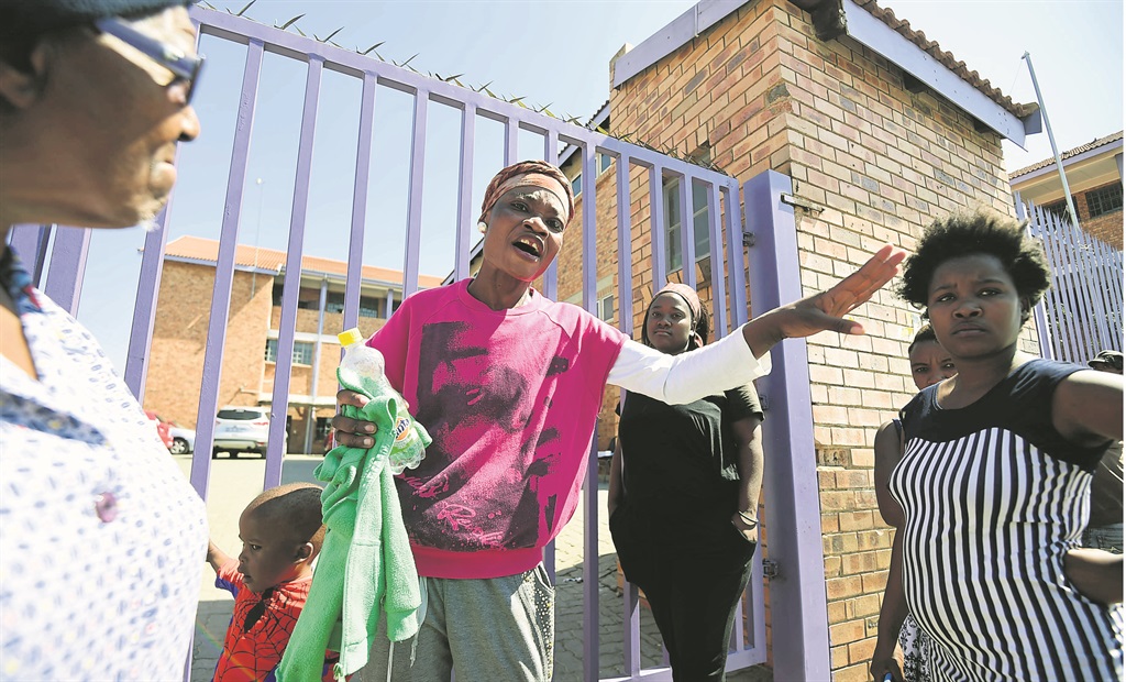 Angry parents gather outside Gordon Primary School in Alexandra after pupils apparently showed strange animal-like behaviour following alleged Satanic rituals.                                      Photo by Everson Luhanga 