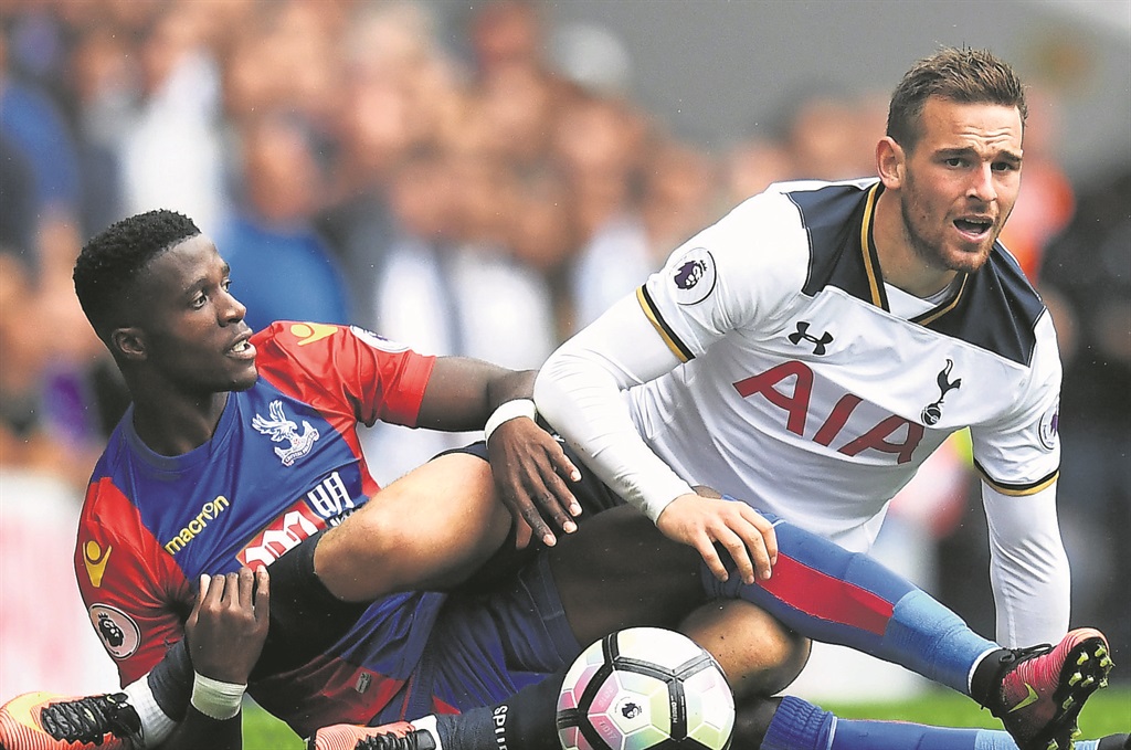 Crystal Palace players and fans want Wilfried Zaha, seen here tackling Vincent Janssen of Tottenham Hotspur (right) for the ball, to stay on at the club.  Photo by Getty Images 