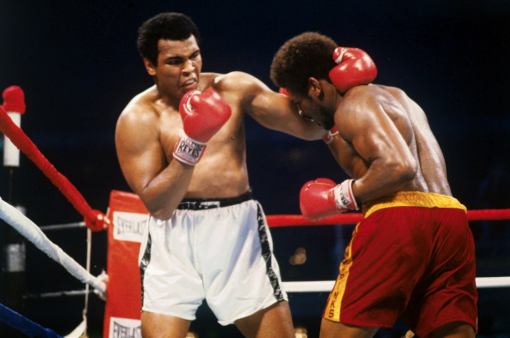 Muhammad Ali holds Leon Spinks' neck with one hand while preparing to hit him with the other hand. (Getty Images)