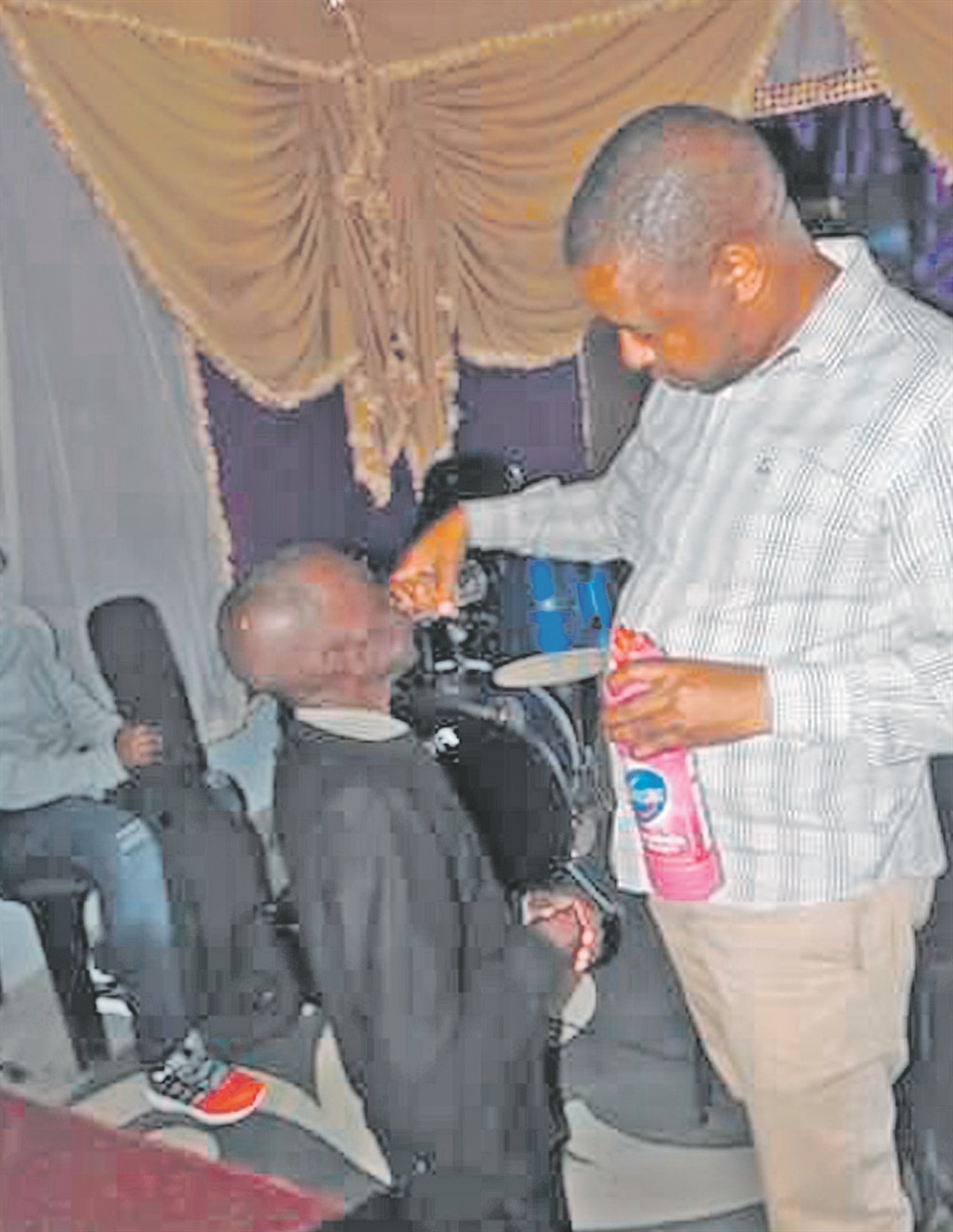 Pastor Sipho Mphakathi gives a member of his church concentrated bleach to swallow.   