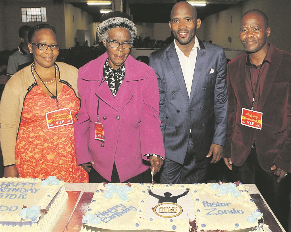 Sister Sthembile Zondo, mum Albertina, Pastor Sthembiso and his brother Mandla stand in front of the pastor’s birthday cake at the new church in Durban.  Photo by Jabulani Langa  