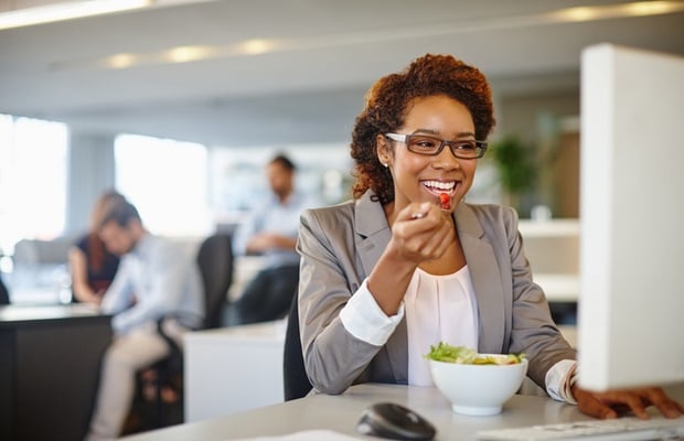 woman eating healthy at her desk