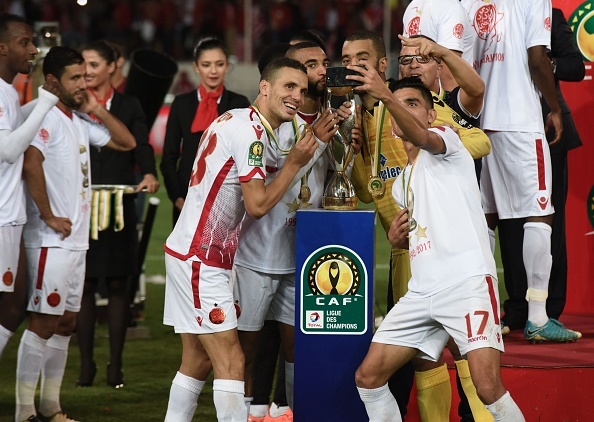 Players of Wydad Casablanca pose for a team photo with the trophy after winning 1-0 in the CAF African Champions League match against Al Ahly at the Stade Mohammed V in Casablanca