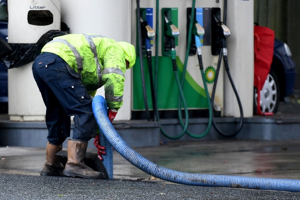 A workman refills the petrol storage tanks at a BP petrol station.