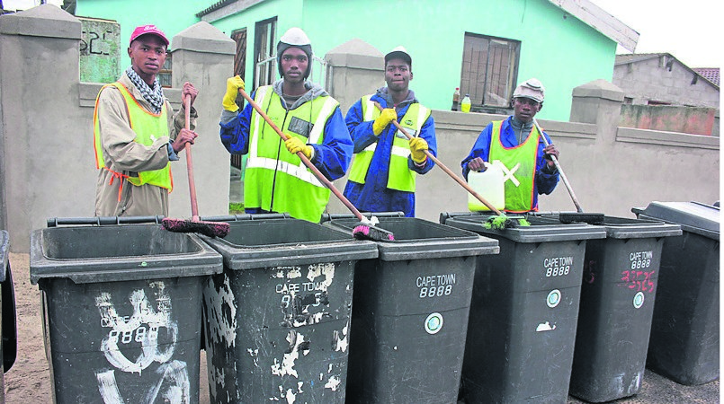 From left Buhle Sithela, Abongile Mqweto, Sivuyile Gwabe and Nicho Brownley cleaning bins at Harare in Khayelitsha on Friday.  Photo by Lindile Mbontsi 