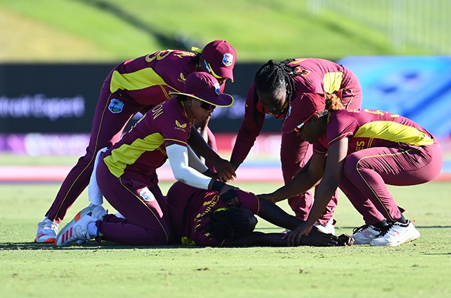 Shamilia Connell of the West Indies is surrounded by team-mates after collapsing. (Photo by Hannah Peters/ICC via Getty Images)