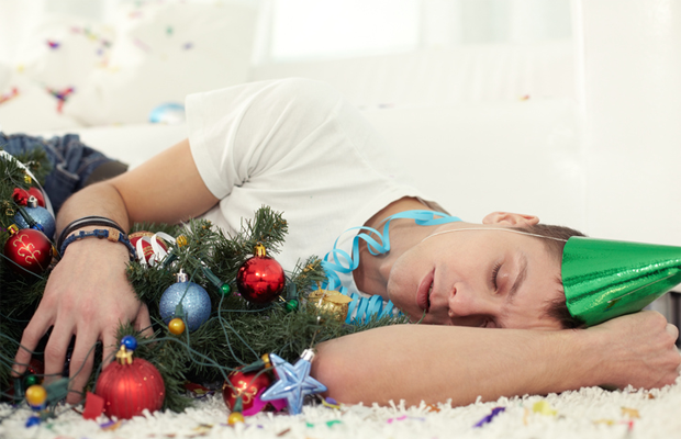 Man sleeping off of a hangover next to a Christmas