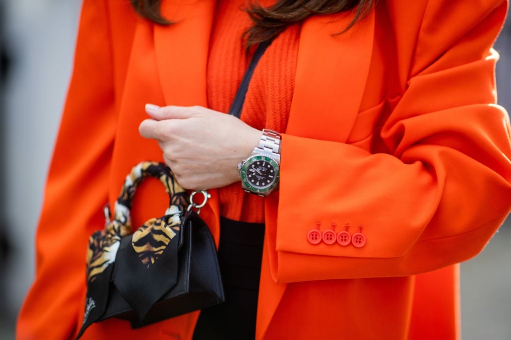 Alexandra Lapp is seen wearing The Attico oversized blazer in orange, Allude knit jumper in orange, Christian Louboutin Elisa top handle mini bag in black, Max Mara high-waist pants in black, limited Rolex Submariner Kermit 16610LV in Dusseldorf, Germany. Photo by Christian Vierig/Getty Images