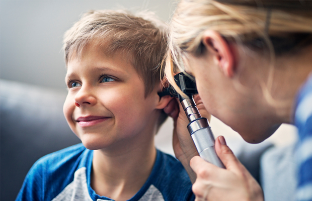 Audiologist checking a boy's ear