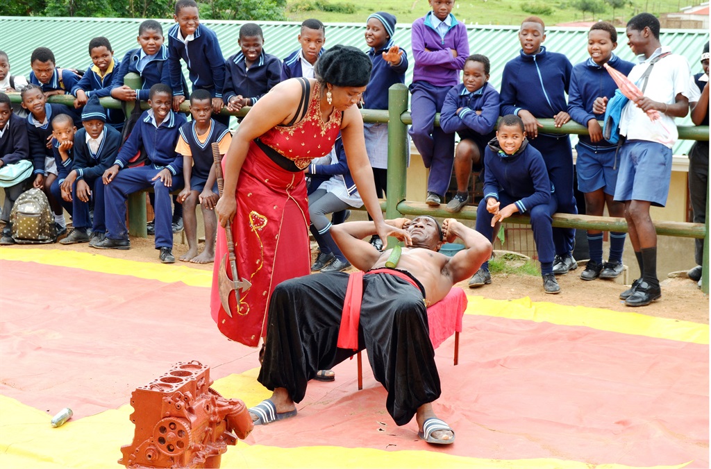 Wife Jemina gets ready to cut a cucumber on Masondo Ngubo’s stomach with an axe.        Photo by                  Siyabonga Simelane 