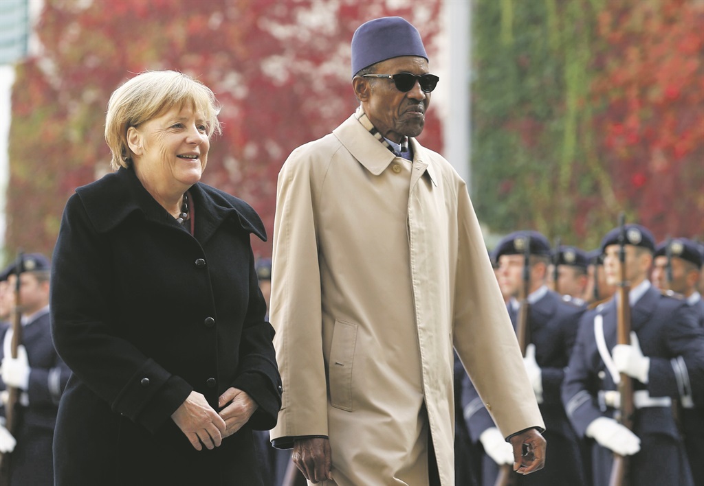PUT A FOOT IN IT German Chancellor Angela Merkel and Nigerian President Muhammadu Buhari review the honour guard during a welcoming ceremony at the chancellery in Berlin, Germany, on Friday. Picture: Reuters 