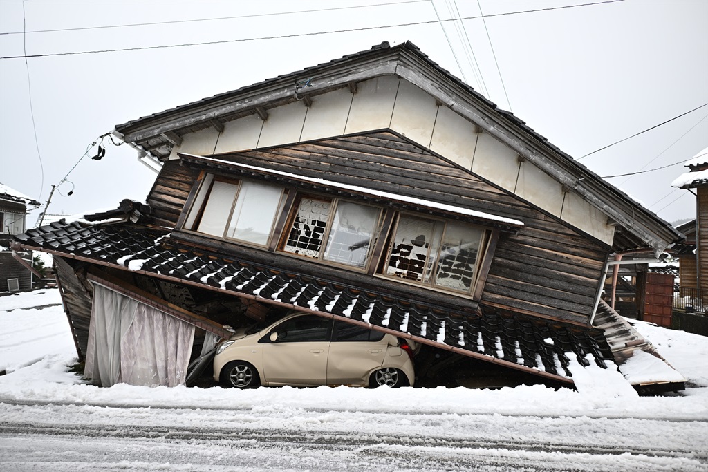 A damaged car lies underneath a collapsed building at Shika town in Hakui District, Ishikawa Prefecture, on 8 January 2024 after a major 7.5 magnitude earthquake struck the Noto region on New Year's Day.