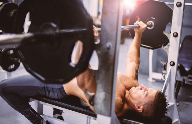 Man bench pressing weights at gym