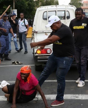 ANC branch secretary in Inner City Zone 12 Thabiso Setona kicks a female Black Land First (BLF) member outside Luthuli House on February 05, 2018 in Johannesburg. (Gallo Images) 