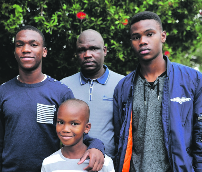 Godfrey Mlaba and his sons, Ntokozo (left), Umnotho (centre) and Lethukukhanya (right) at their home in Klippoortjie, Boksburg. Picture: TEBOGO LETSIE