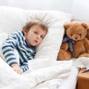 Child sick in bed with a cough
