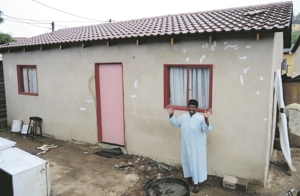 Happy Alvina Silangwe stands outside her new house.        Photo by Siyabonga Simelane 