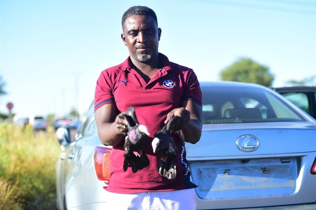 Veli Monare with the pigeons that helped to get his hijacked car back. Photo by Raymond Morare