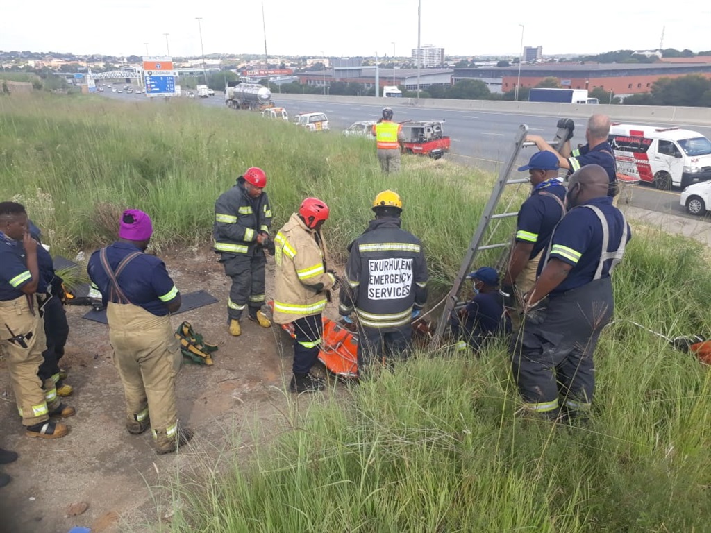 Emergency services workers rescue a man from a drain in Alberton, Gauteng.