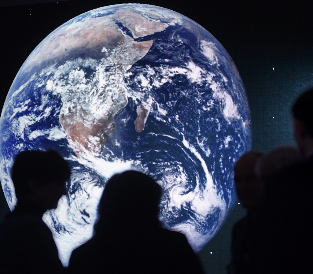 A picture of Earth is shown on a giant screen behind participants of a panel session on the closing day of the 47th annual meeting of the World Economic Forum in Davos, Switzerland, this week. The meeting brings together entrepreneurs, scientists, chief executives and political leaders. Picture: EPA 