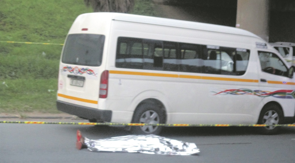 The body of taxi conductor Mthandeni Sigwaza lies next to the taxi.                                                              Photo by Willem Phungula 