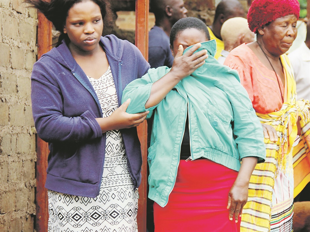 Weeping relatives at the scene of the murder.   Photo by  Armando Chikhudo 