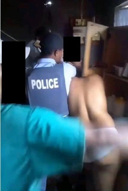 A screenshot from video of naked women fighting cops. 