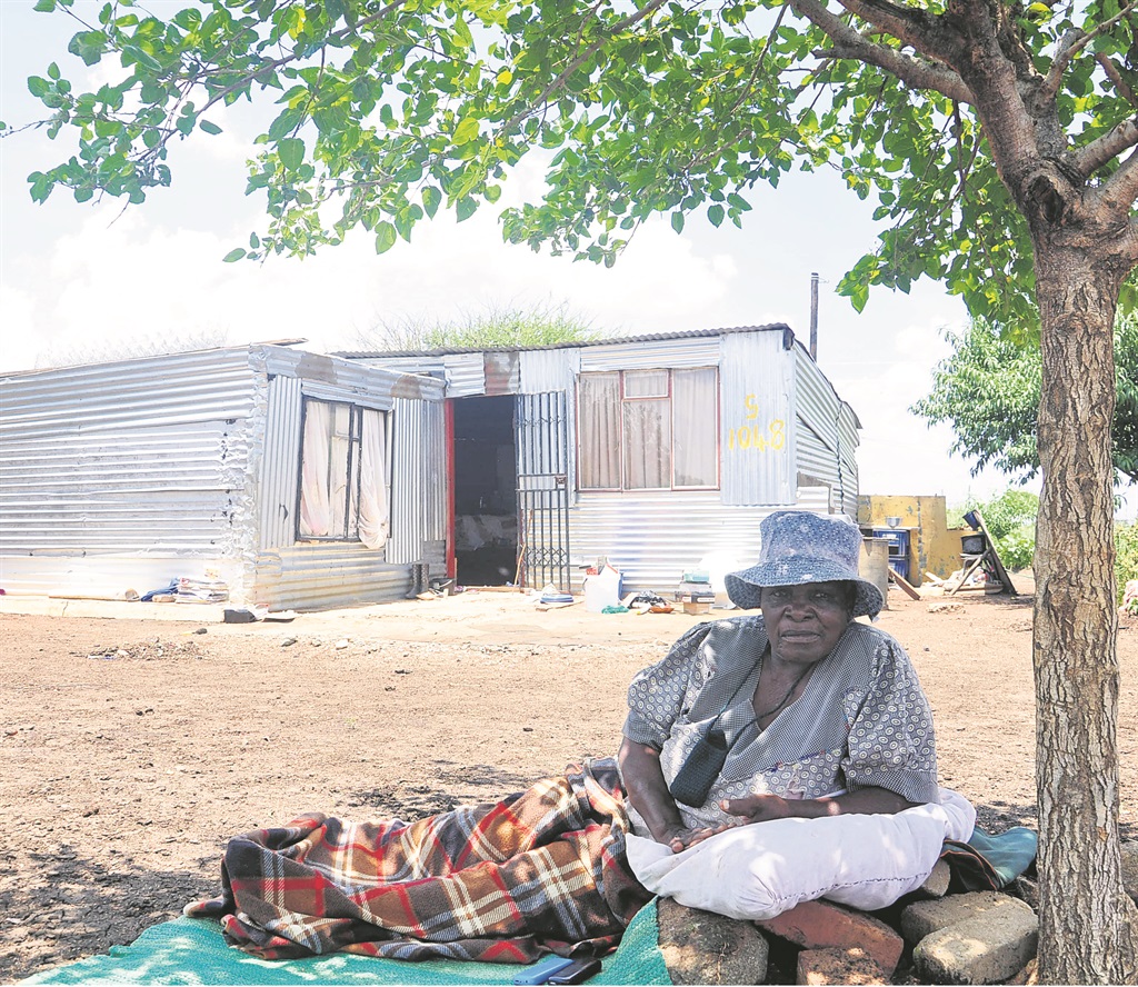 Gogo Sarah Mogwane would rather sleep under this tree than share her shack with a cobra.                 Photo by Samson Ratswana   