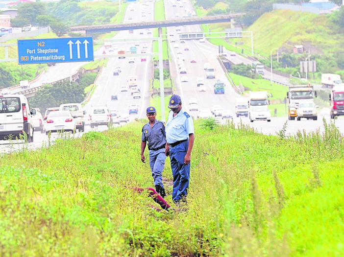 Police inspect the area where John Nkomo’s body was discovered on Tuesday. Photo by Jabulani Langa