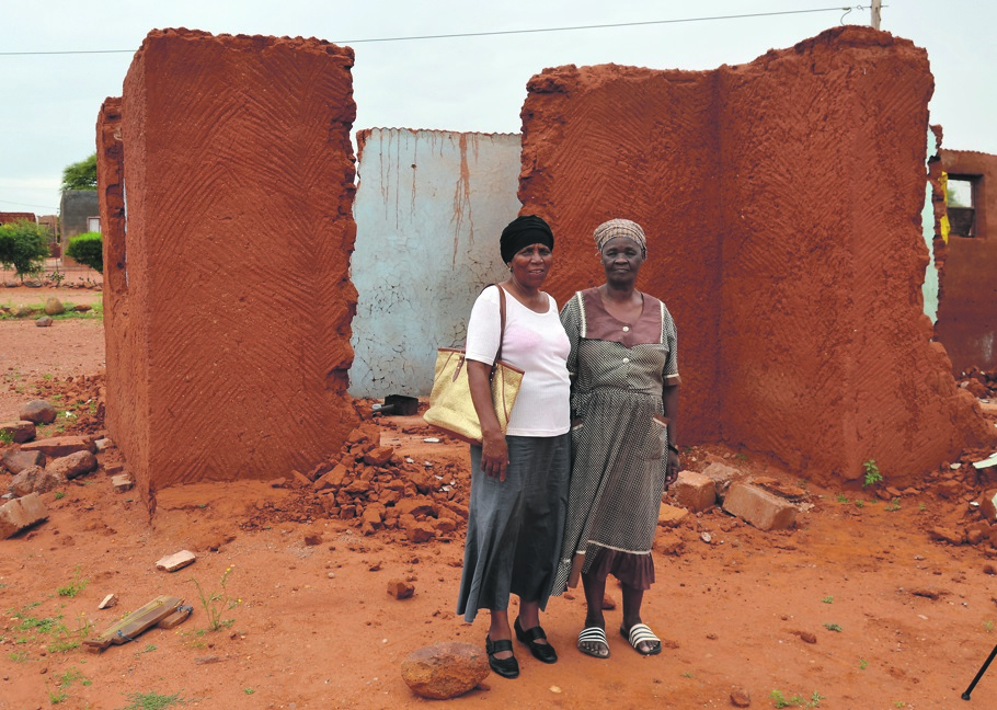 Neighbour Mita Ipelegeng helps Motlalepula Obusitse.                    Photo by Reginald Kanyane
