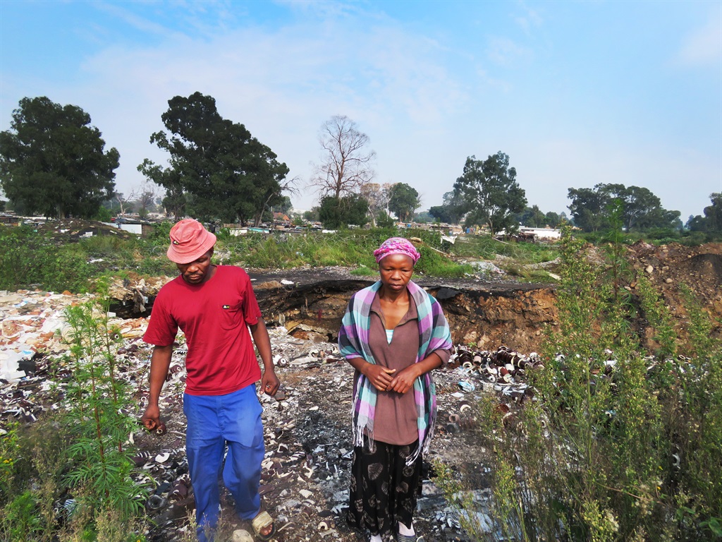Mishack Mohlala and Nombeko Thole, leaving the site of the old mine shaft in Jerusalem, Boksburg, where their five-year-old son Richard Thole fell in . Picture: Poloko Tau/City Press
