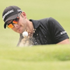 DETERMINED:  Dean Burmester scoops the ball from a bunker during the final round of the Tshwane Open. (Luke Walker,  Sunshine Tour, Gallo Images)
