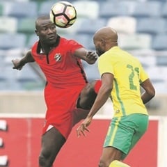 BATTLE:  Bafana Bafana’s Ramahlwe Mphahlele is kicked by Francisco Silva Junior of Guinea-Bissau.  (Anesh Debiky, Gallo Images)
