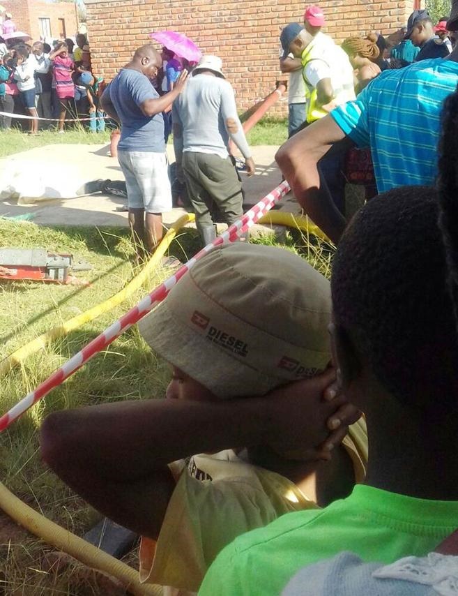 Residents of Clocolan stand around in shock as divers remove Kananelo Salemane’s body. 
Photo by Ishmael Ntholeng 
