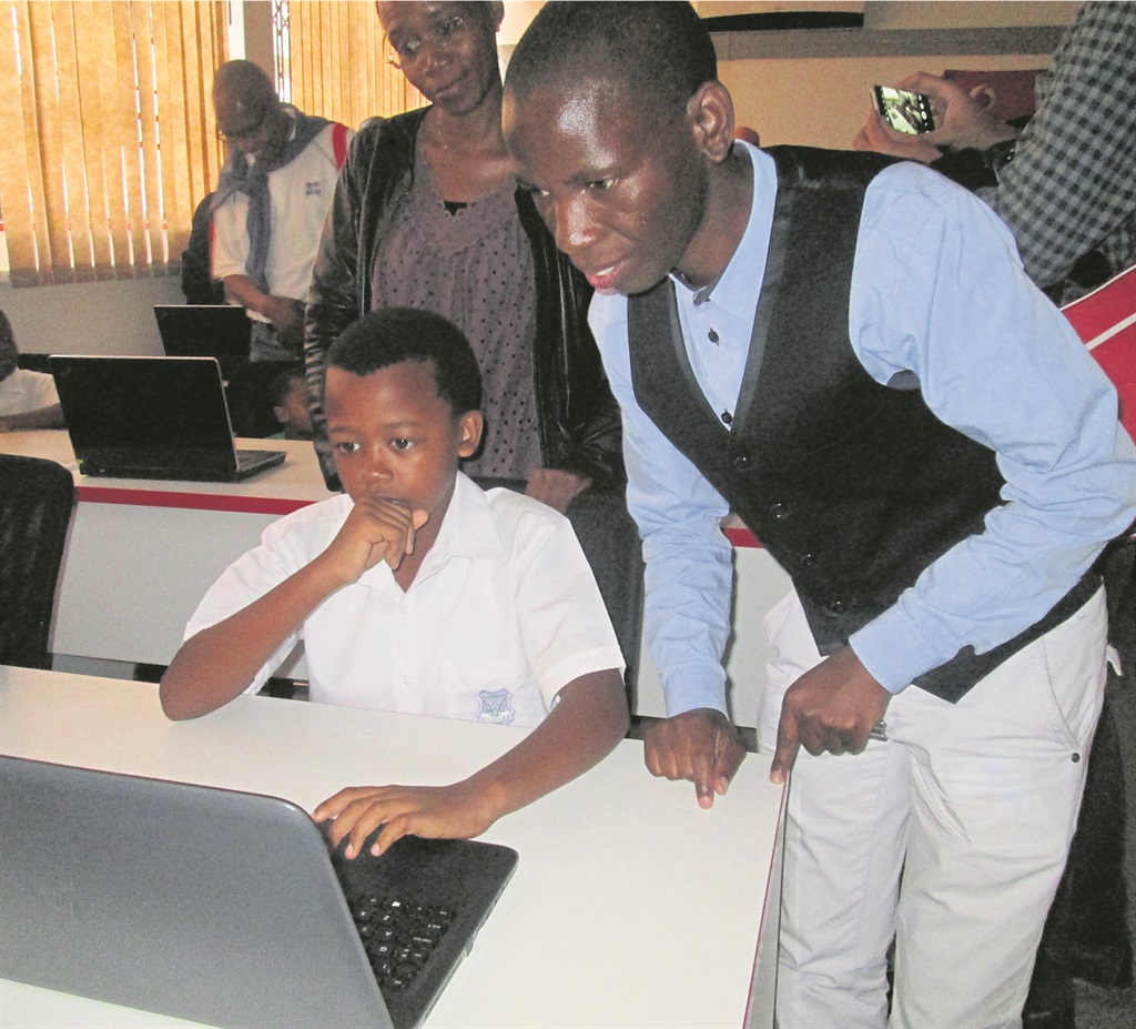 Zamo Buthelezi shows pupil Qaphela Ngcamu how to use a laptop in Durban.         Photo by          Mbali Dlungwana