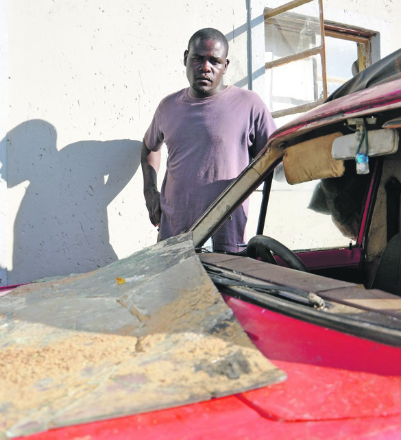 Prosper stands next to his bakkie after the windscreen was allegedly kicked out by an angry neighbour.                       Photos by Samson Ratswana
