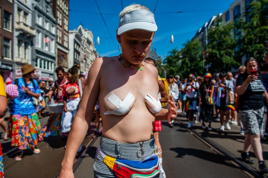 A woman wearing adhesive tape to cover her nipples, during Pride walk in Amsterdam.