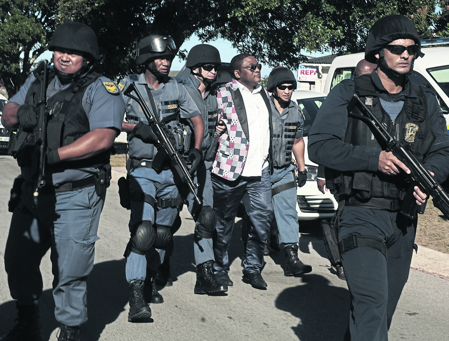 The neatly dressed prophet, who was arrested at the Port Elizabeth Airport, is escorted by heavily armed police. Photo by Chris Qwazi