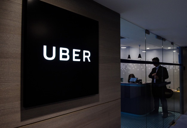 <b> UNDER FIRE: </b>  This file photo taken on March 10, 2017 shows Uber signage at the Hong Kong office. Hong Kong police arrested 21 Uber drivers for carrying passengers without a proper permit. <i> Image: AFP / Anthony Wallace </i>
