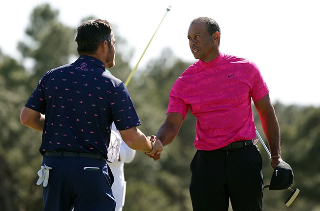 South Africa's Louis Oosthuizen and Tiger Woods shake hands on the 18th green after finishing their first round of the Masters at Augusta National Golf Club on 7 April 2022. (Photo by Jamie Squire/Getty Images)