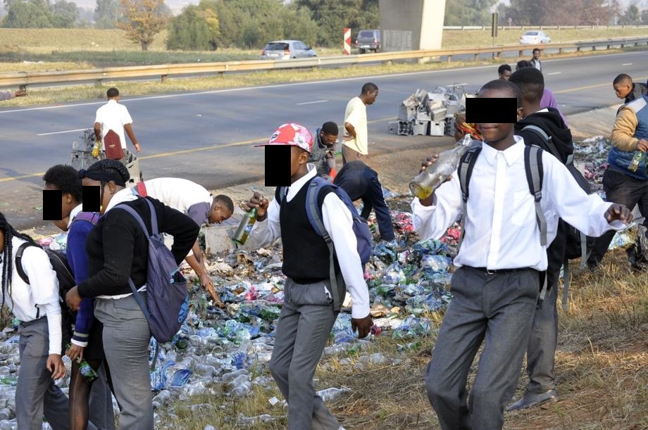 Schoolkids in uniform enjoyed the free booze spilled on the N12 freeway near Avalon Cemetery, Soweto.Photo by Sammy Moretsi