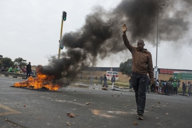 A resident tries to calm the situation in Eldorado Park on Monday, but without any success as the violence escalated. Picture: Ihsaan Haffejee, Ground Up