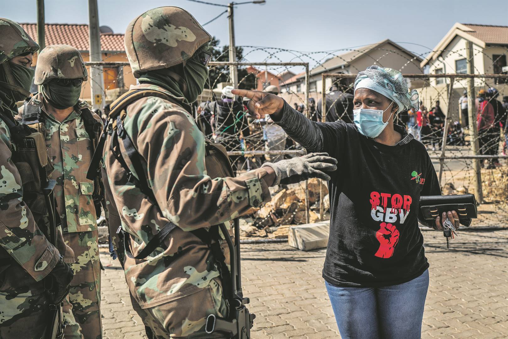 ’n Vrou redekawel die afgelope Woensdag met ’n soldaat terwyl die Rooimiere met die hulp van die leër en polisie 2 000 onwettige besetters uit ’n behuisingsontwikkeling in Johannesburg sit. Foto: Jerome Delay, AP