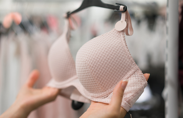 Woman holding bra in shop