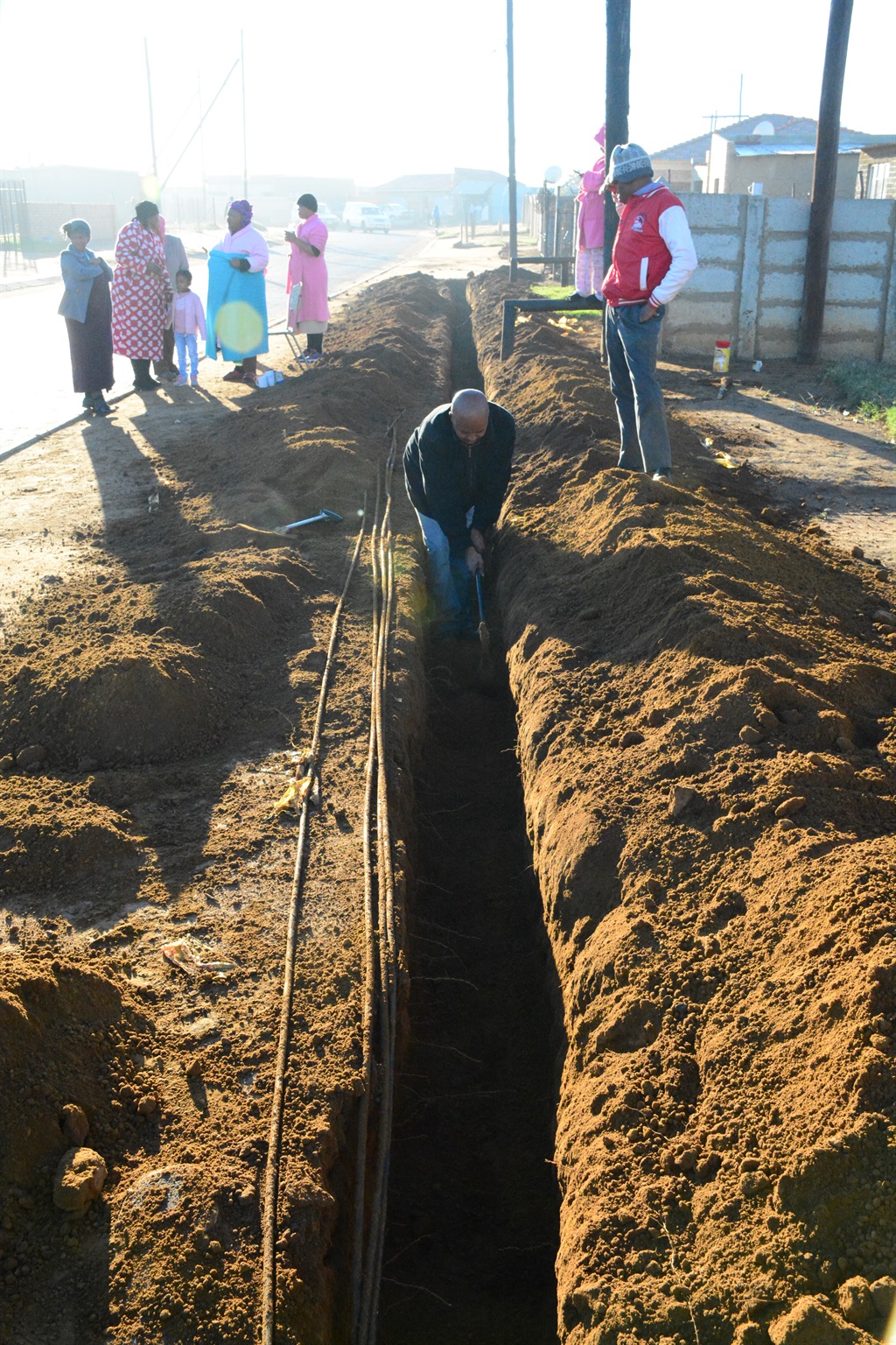 The community of Geluksdal in Ekurhuleni says they are tired of Izinyoka, so they dig up holes for for themselves to put down the cables. Photo by Muntu Nkosi