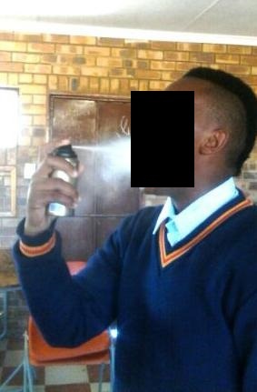 A pupil demonstrates his powers in front of fellow pupils by spraying deodorant into his mouth. Photo by Samson Ratswana.