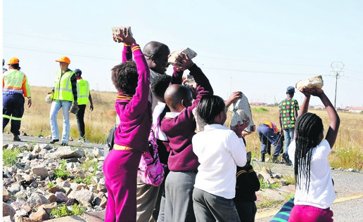 Kasi pupils helped to clear the busy R28 after a protest.               Photo by      Sammy Moretsi