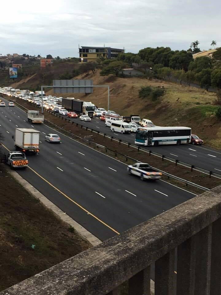 A bus is parked in the middle of the freeway. 