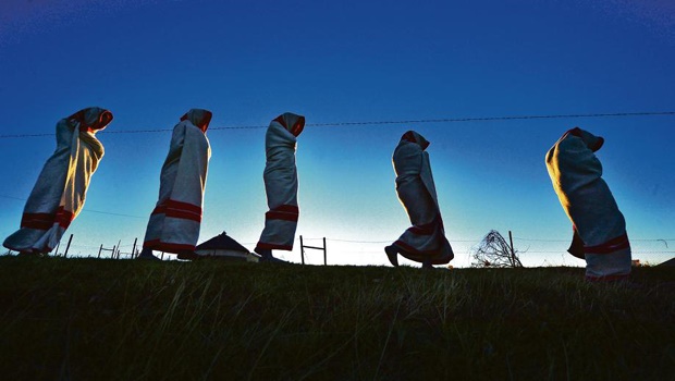 A group of initiates, covered in red-and-white blankets, during an initiation ritual
PHOTO: LEON SADIKI
