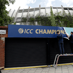 Men put up a poster for the ICC Champions Trophy at The Oval (AP) 